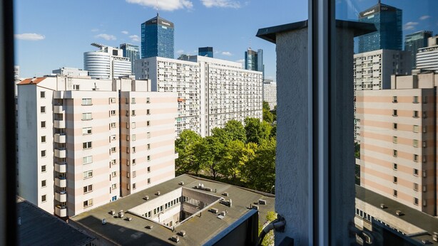 Un immeuble de grande hauteur, doté de nombreux étages, de grandes fenêtres et d’un toit plat.