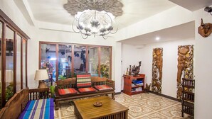 A living room with a sofa, a coffee table, and decorative items. - Somwang Boutique House (Chiang Mai)