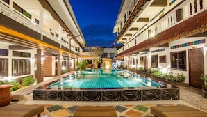 A pool area with a central pool, surrounded by lounge chairs and potted plants. - Somwang Boutique House (Chiang Mai)