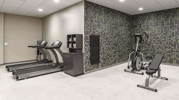 A gym with treadmills, an elliptical, and a weight bench.
