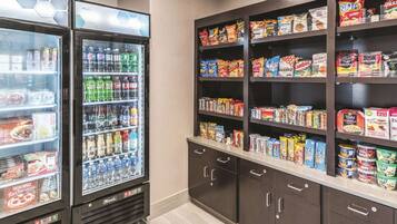 A vending area with a variety of snacks and drinks, including microwavable meals and bottled beverages.