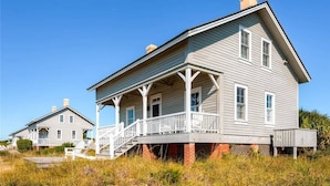 A two-story house with a porch and a chimney.