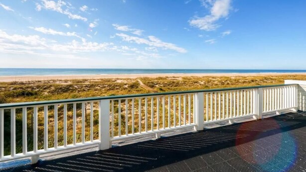 A beach view from a balcony with a white railing. - Footprints In The Sand 4 Bedroom Holiday Home By Bald Head Island (Bald Head Island)