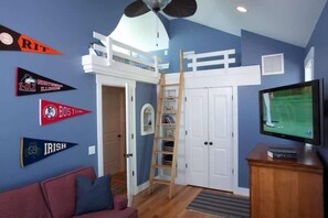 A room with a loft bed, a TV, and sports pennants on the wall. - Gone To Carolina 5 Bedroom Holiday Home By Bald Head Island (Bald Head Island)