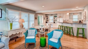 A modern kitchen with white cabinets, a central island, and green bar stools. - Island Retreat 4 Bedroom Holiday Home By Bald Head Island (Bald Head Island)