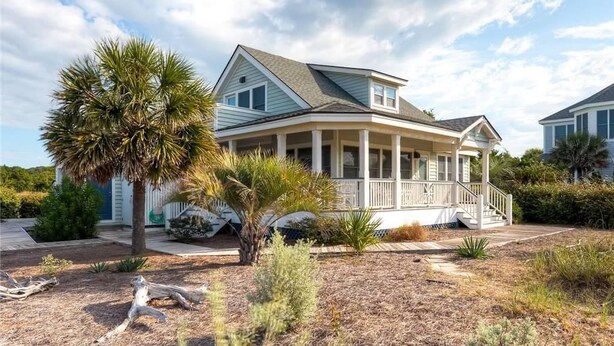 A coastal house with a wrap-around porch, palm trees, and a clear sky. - Island Retreat 4 Bedroom Holiday Home By Bald Head Island (Bald Head Island)