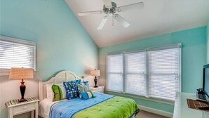 A bedroom with a bed, two nightstands, a ceiling fan, and a TV. - Island Retreat 4 Bedroom Holiday Home By Bald Head Island (Bald Head Island)