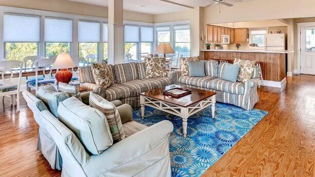 A spacious living room with a large sectional sofa, a coffee table, and a patterned rug. - JJ s Hideaway 4 Bedroom Holiday Home By Bald Head Island (Bald Head Island)