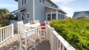 A deck with white chairs and a table, surrounded by a white railing. - JJ s Hideaway 4 Bedroom Holiday Home By Bald Head Island (Bald Head Island)