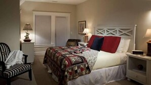 A bedroom with a bed, a chair, a nightstand, and a window with blinds. - Kate s Choice 5 Bedroom Holiday Home By Bald Head Island (Bald Head Island)