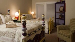 A bedroom with a bed, two bedside tables, a chair, a wardrobe, and a shelf with decorative items. - Kate s Choice 5 Bedroom Holiday Home By Bald Head Island (Bald Head Island)