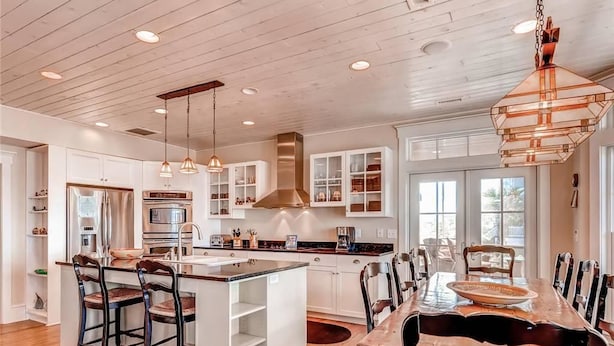 A spacious kitchen with a large island, white cabinetry, and pendant lighting. - Summer Island 6 Bedroom Holiday Home By Bald Head Island (Bald Head Island)
