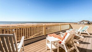 A wooden deck with beach chairs and a table overlooking the ocean. - Summer Island 6 Bedroom Holiday Home By Bald Head Island (Bald Head Island)
