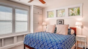 A bedroom with a bed, two bedside tables, a ceiling fan, and a window with blinds. - Tiburon Marsh 4 Bedroom Holiday Home By Bald Head Island (Bald Head Island)