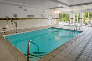 An indoor swimming pool with clear signage, including a lifeguard duty sign, and a tiled floor. - Courtyard by Marriott Detroit Farmington (Farmington Hills)