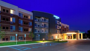 A Courtyard by Marriott hotel with a parking lot, marked handicapped spaces, and a well-lit entrance. - Courtyard by Marriott Detroit Farmington (Farmington Hills)