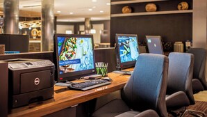 A hotel reception desk with two monitors, a Dell printer, and a laptop. - Courtyard by Marriott Detroit Farmington (Farmington Hills)