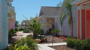 A residential area with houses, a pathway, and various plants. - Sun Castle PB221 (Port Aransas)