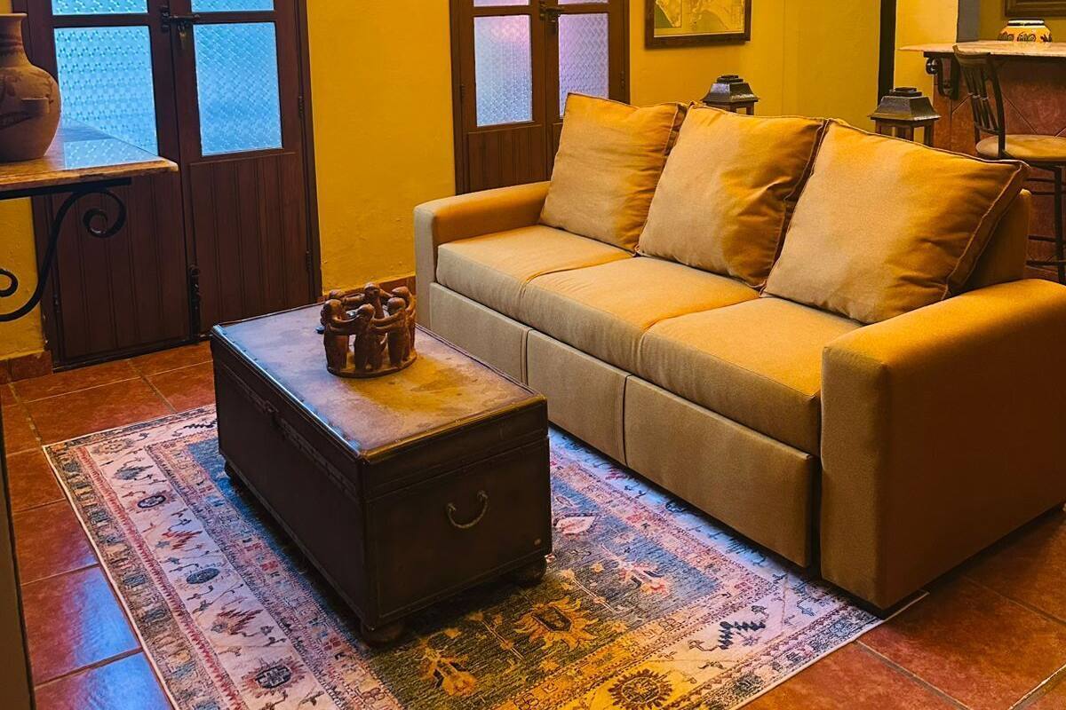 A cozy living room with a sofa, a coffee table, and a patterned rug.