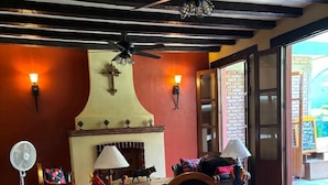 A cozy interior with a fireplace, wooden furniture, and a tiled floor.