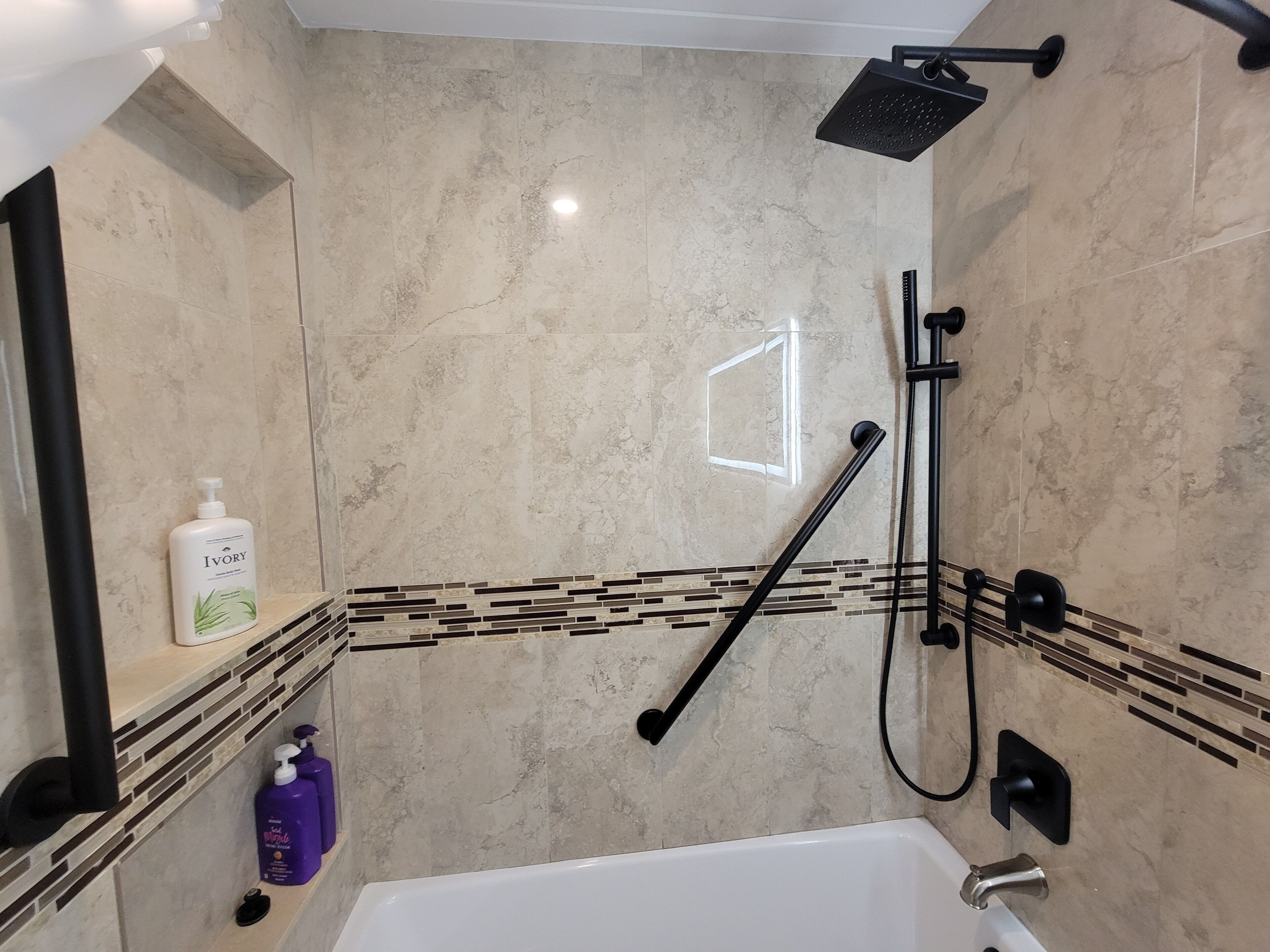 Un baño moderno con bañera, ducha y tocador con espejo.