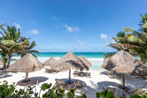 Pantai pribadi, kursi berjemur, payung pantai, dan handuk pantai