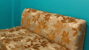 Una pared color turquesa con un sofá estampado con motivos florales.