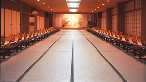 Une salle de conférence avec des rangées de chaises et une scène à l’avant.