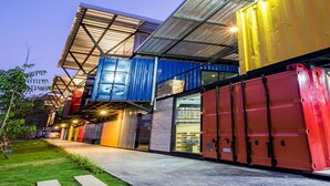 A modern building with a unique architectural design featuring large shipping containers as walls. - Sleep Cube (Khon Kaen)