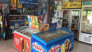 A food court with ice cream vendors, a vending machine, and a refrigerated display. - Riviera Caravan Park (Sussex Inlet)