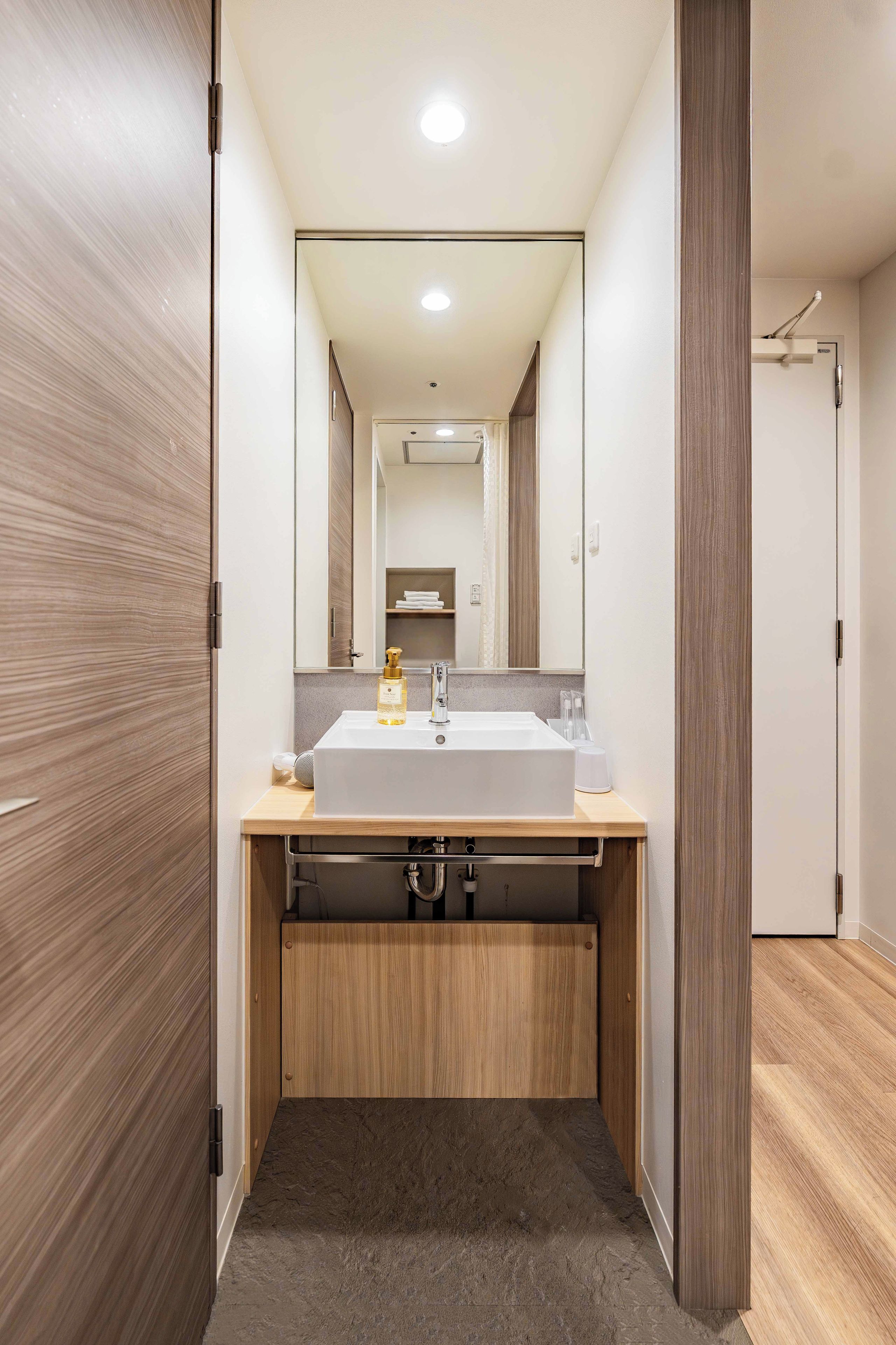 Une salle de bain moderne avec un meuble-lavabo en bois, un évier et un miroir.