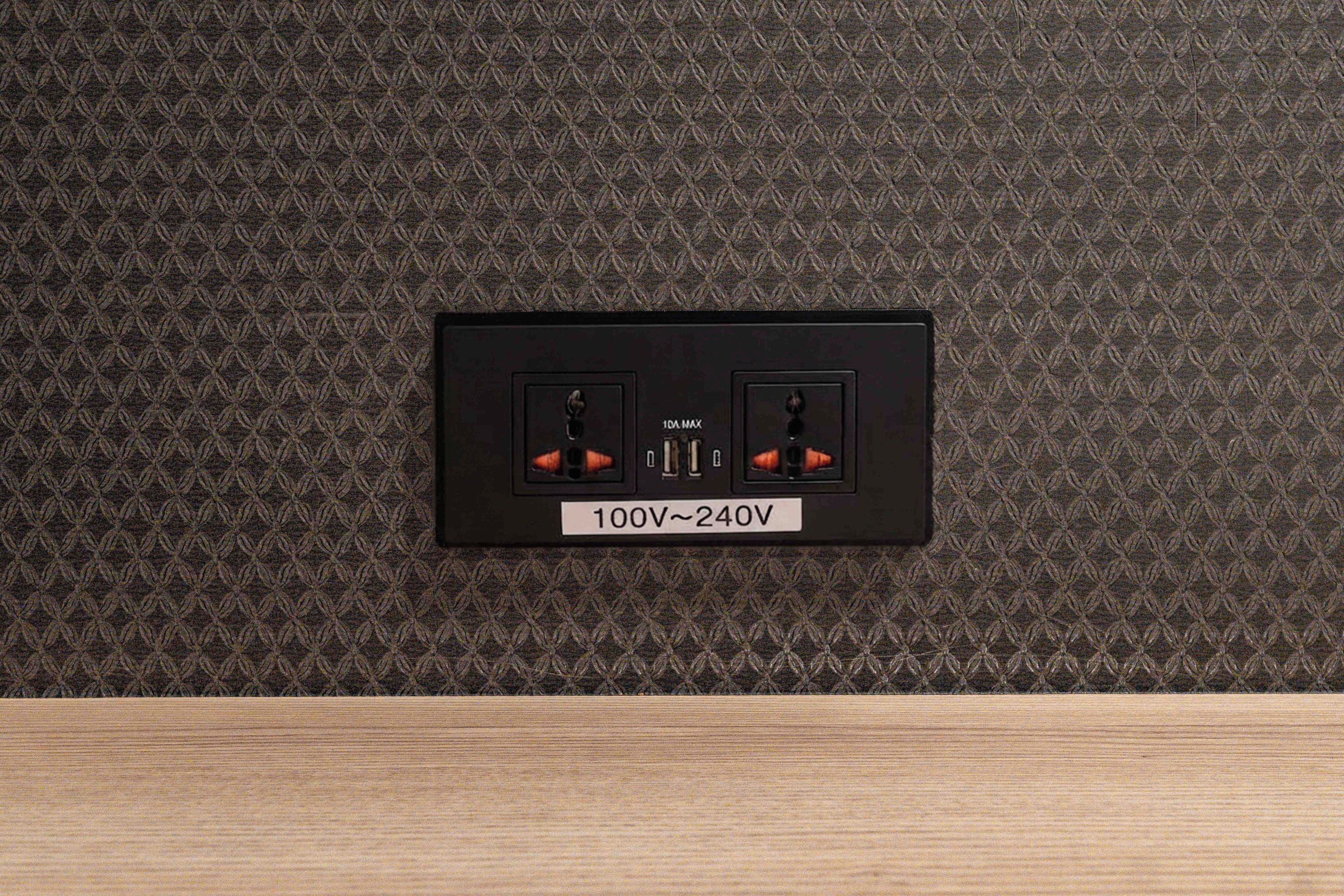 A power outlet with a switch and a label indicating 100V-240V.