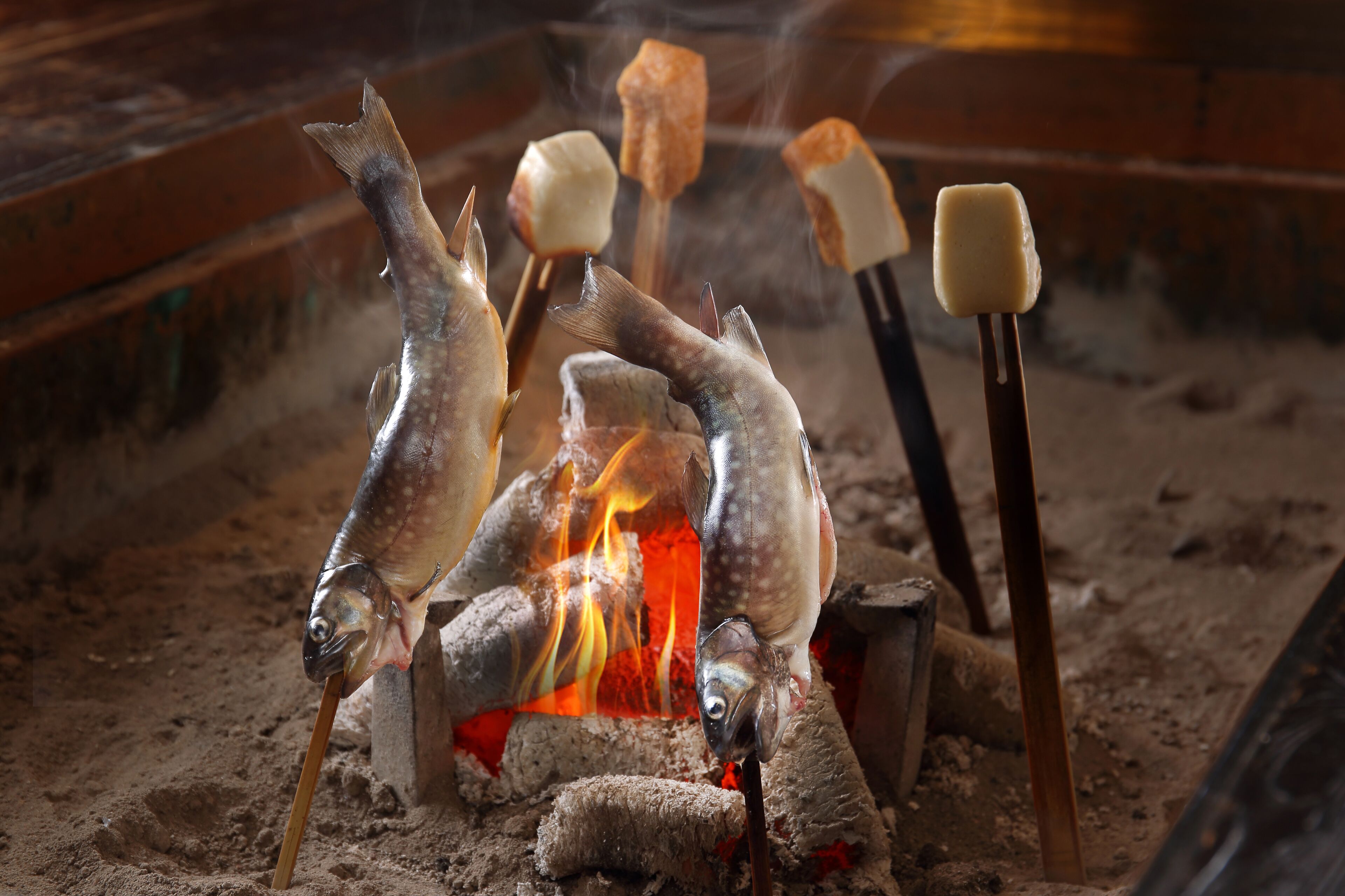 Pescado en brochetas sobre fuego con malvaviscos.