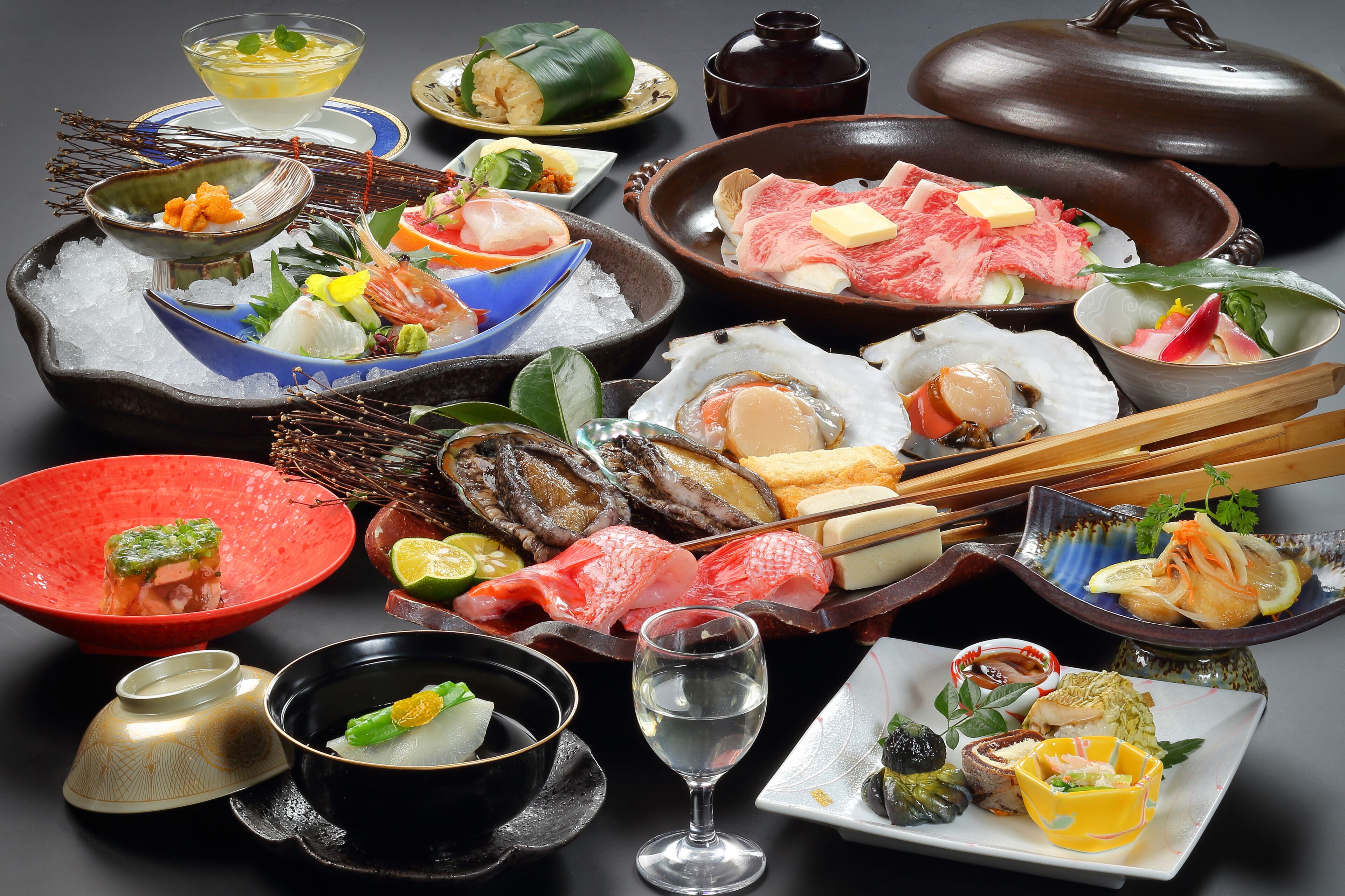 Forskellige japanske retter, heriblandt sushi, sashimi og andet fisk og skaldyr, serveret på is og i skåle.