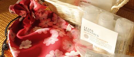 A basket with a floral bag, a beauty kit, and some botanical products.