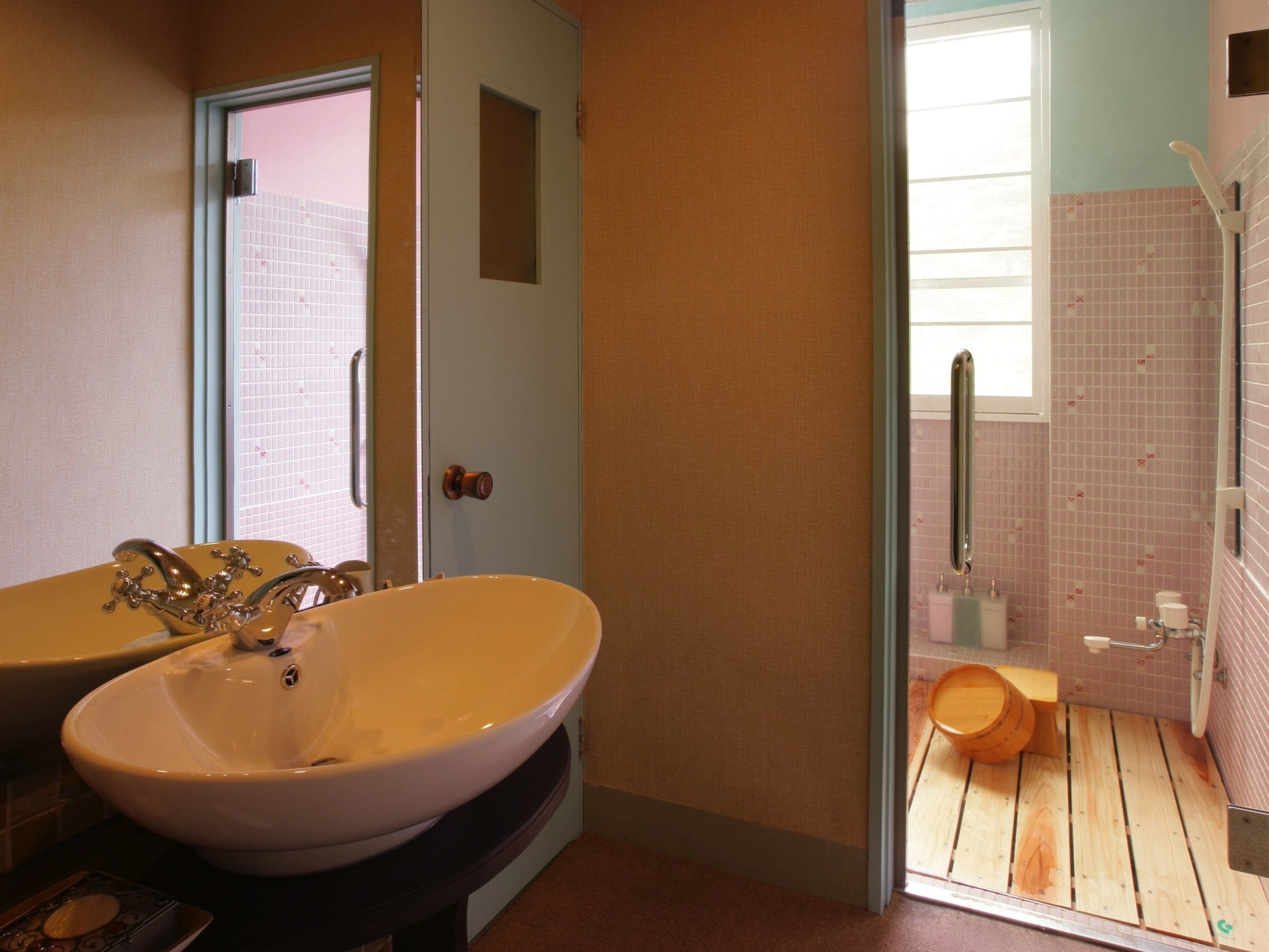 Un baño con un lavamanos grande, un inodoro y una zona de ducha.