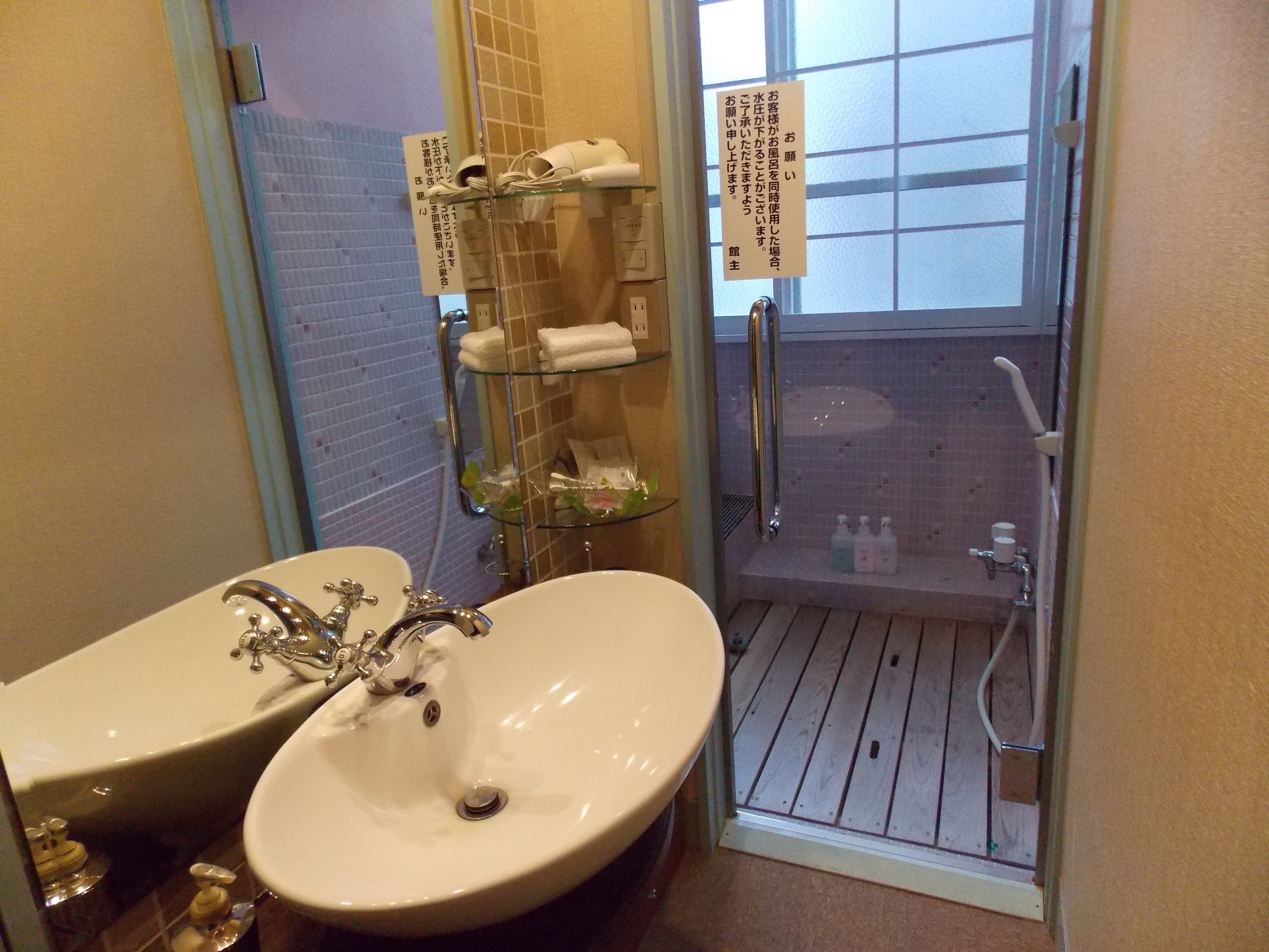 A bathroom with a sink, mirror, and a glass shower enclosure.