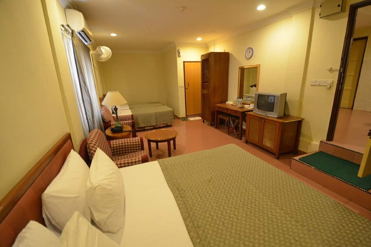 Une chambre d’hôtel équipée d’un lit, d’un bureau, d’une télévision et d’une armoire.