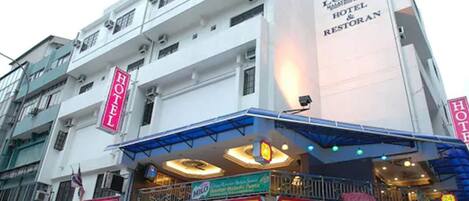 Un edificio de varios pisos con letreros que indican un hotel y restaurantes.