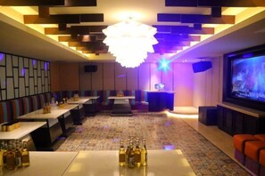 A modern bar area with tables, a bar counter, and a television screen. - Narada Resort & Spa Phoenix Valley (Jinhua)