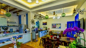 A spacious kitchen with modern appliances, a dining area with wooden furniture, and a variety of hanging lights.