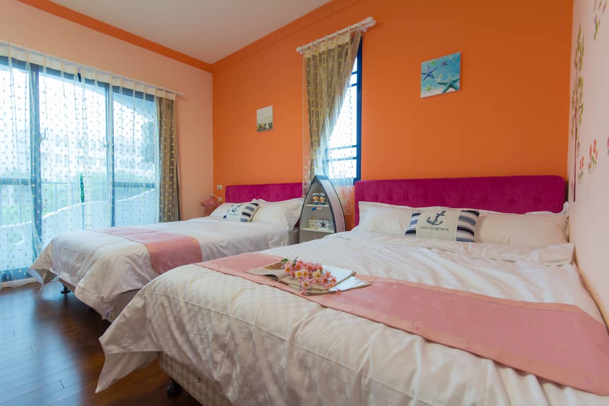 A hotel room with two beds, a window with curtains, a nightstand, and a wall clock.