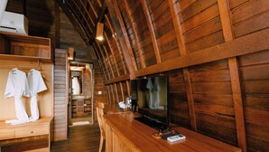 A wooden interior with a TV on a wooden counter, a bench with towels, and a wooden ceiling. - Puri Pandawa Resort (Kutuh)