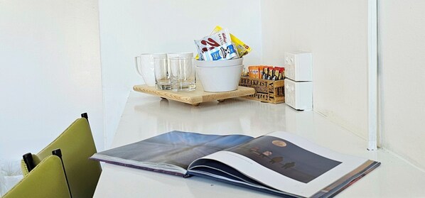 A table with a magazine, a bowl of snacks, and a box of breakfast items.