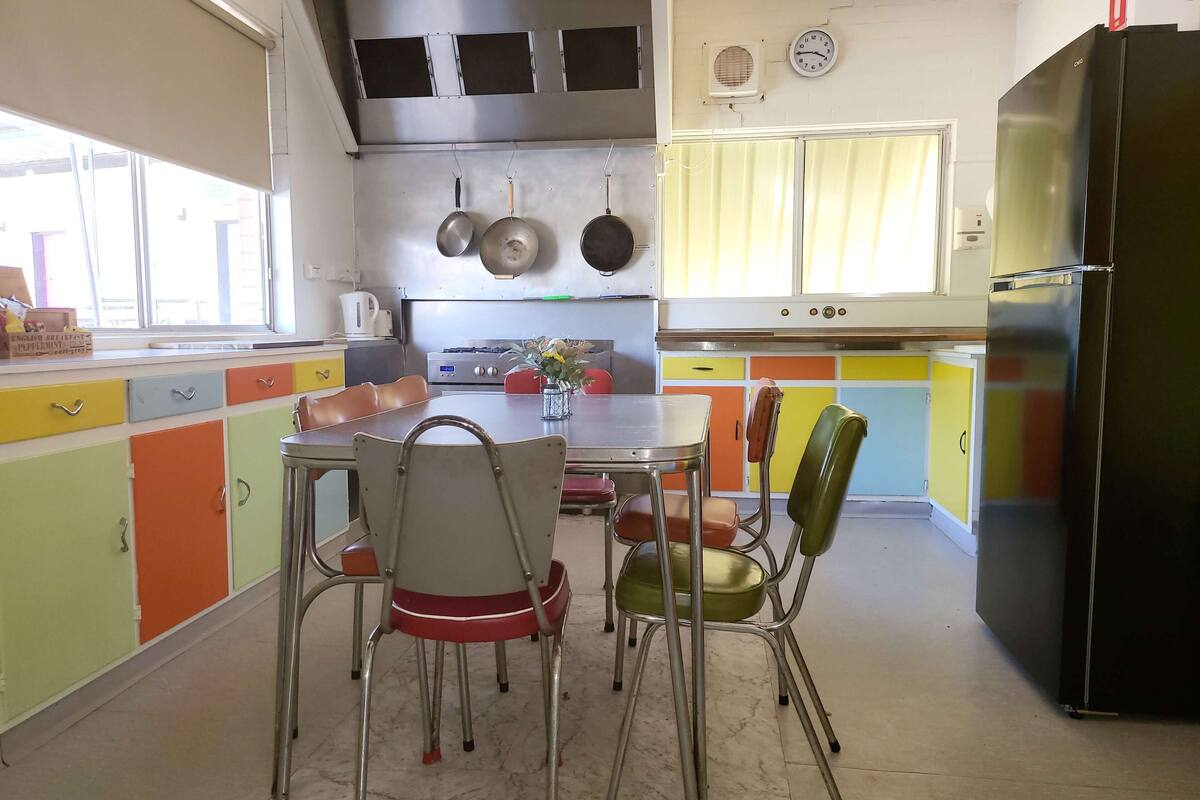 Eine Küche mit Esstisch, Stühlen und einem Kühlschrank.