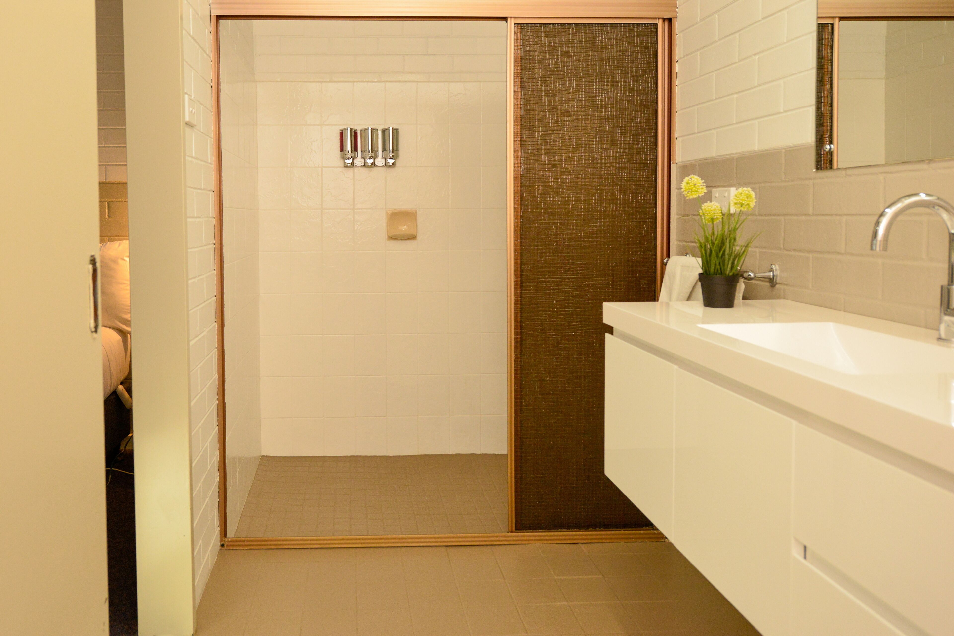 Ein modernes Badezimmer mit Dusche, Waschbecken und Spiegel.