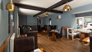 A restaurant with wooden flooring, dark ceiling beams, and pendant lighting. - The Queens Head Hotel Self Check In (Berwick-upon-Tweed)