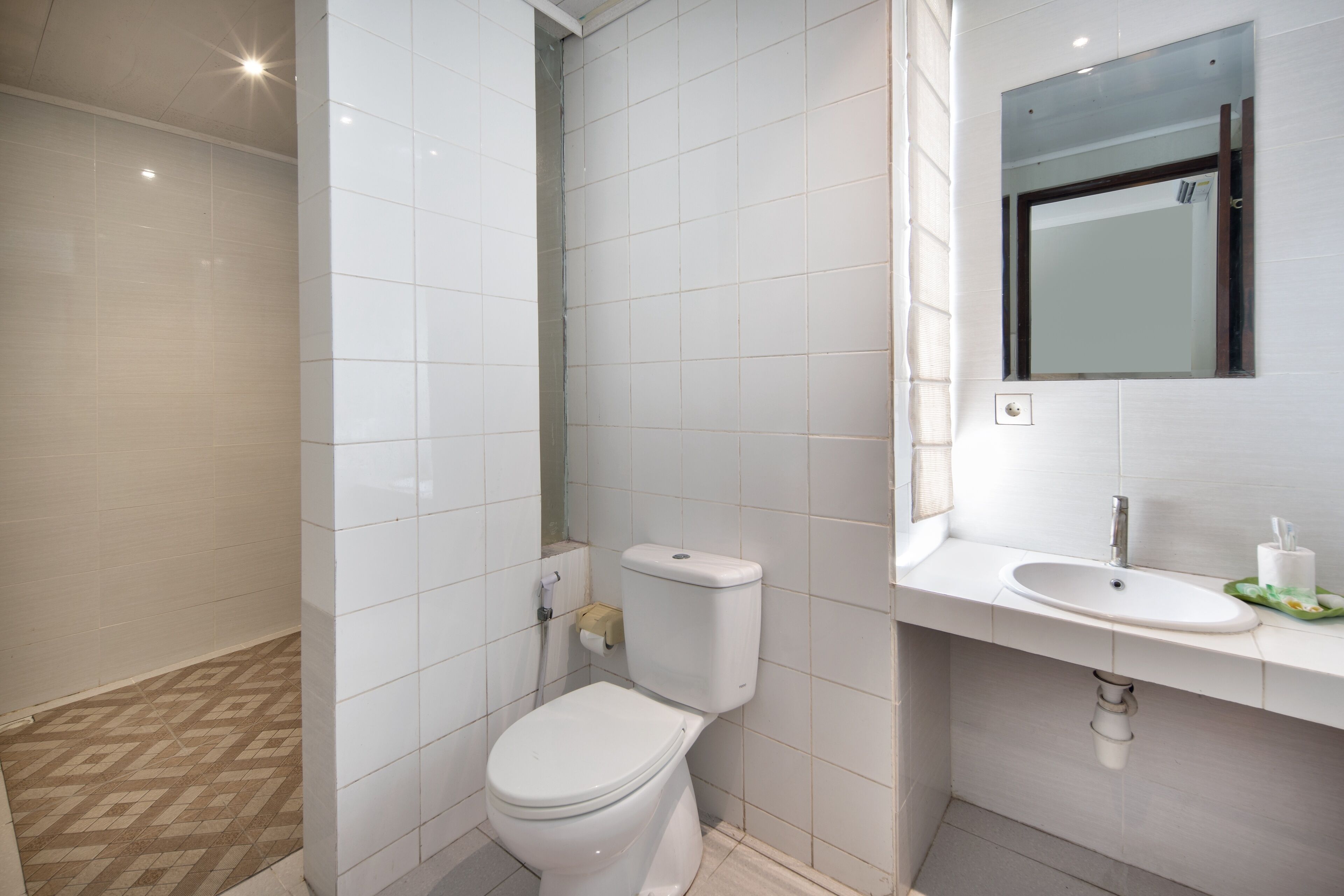 A modern bathroom with a toilet, sink, and mirror.