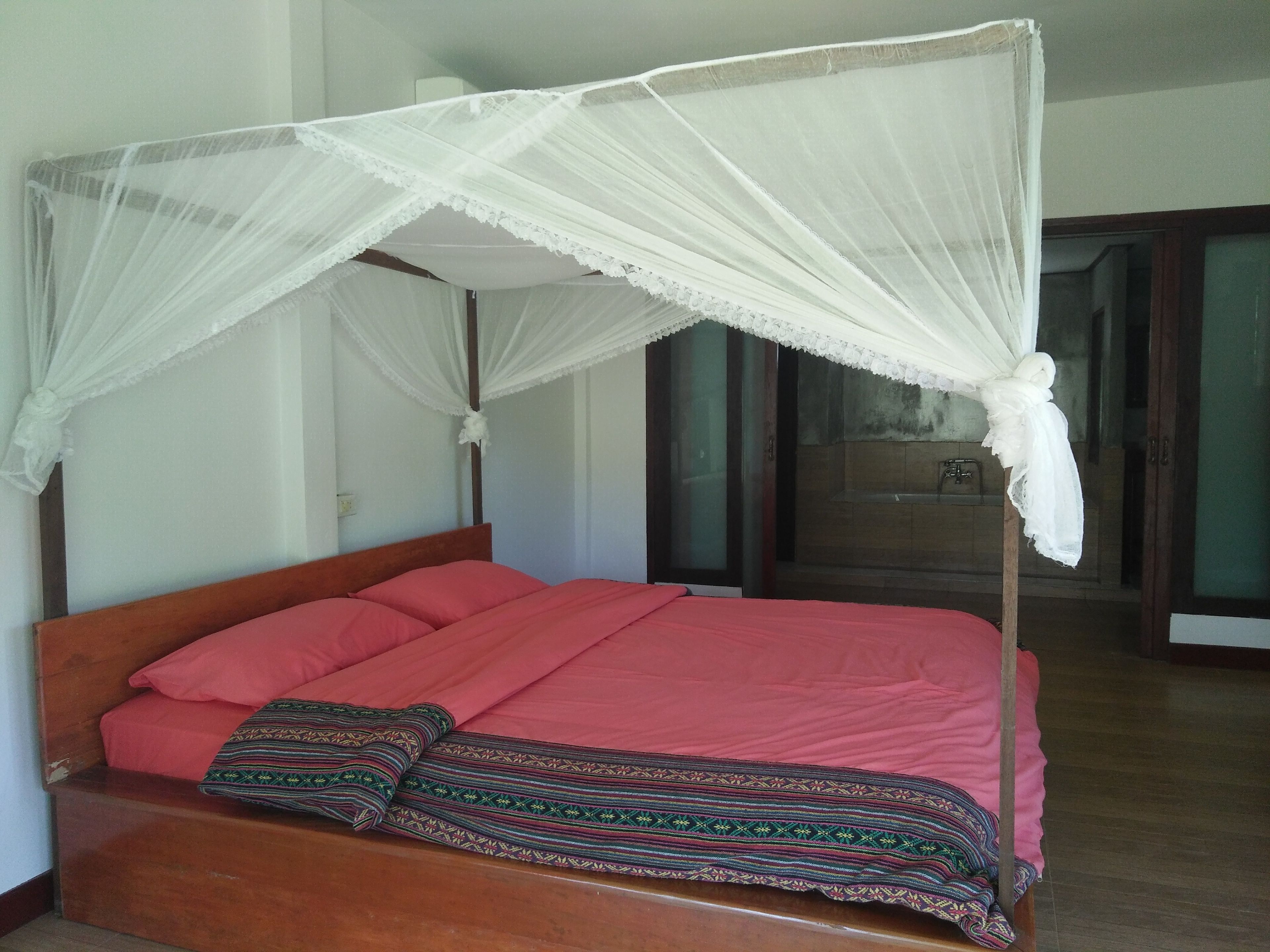 Una cama con estructura de madera y dosel.