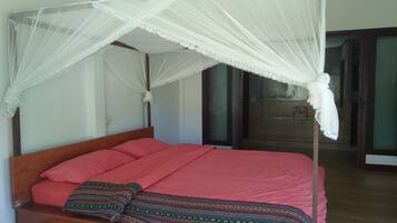 Una cama con estructura de madera y dosel.